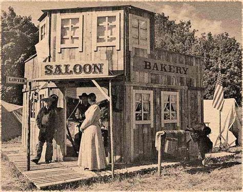 An Old Black And White Photo Of People Standing In Front Of A Saloon