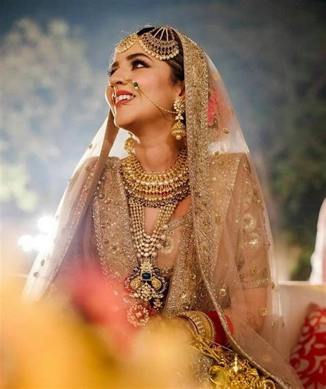 a woman in a bridal outfit smiles at the camera while she sits down and looks off to the side
