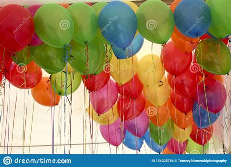 Colourful Bunch Of Helium Balloons With Ribbons Handing Down Stock