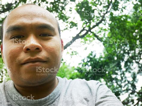 Bald Asian Man Smiling Portrait And Branch Tree Background In The