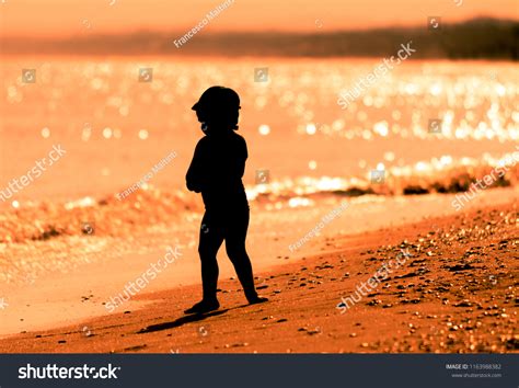Silhouette Little Girl Playing On Beach Stock Photo 1163988382