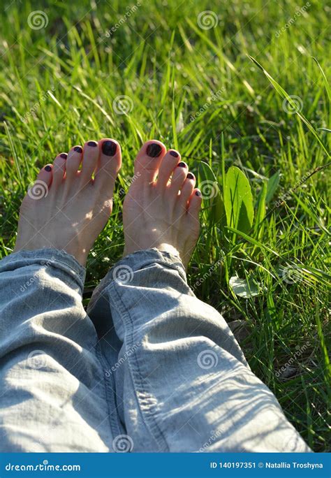 Female Barefoot Resting On The Green Grass Background Stock Image