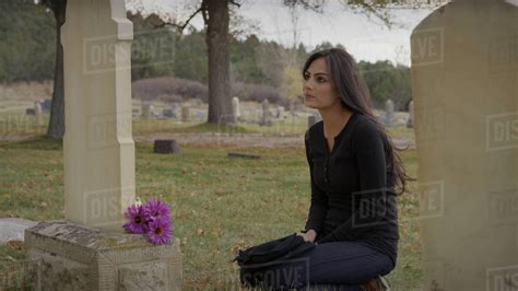 Sad Pensive Woman Sitting At Grave In Lonely Cemetery