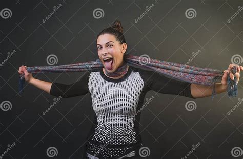 Attractive Woman Choking Her Self With A Silk Scarf And Sticking Her Tongue Out While Smiling