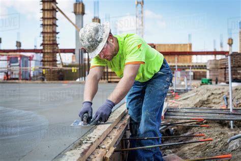 Construction Worker Finishing Concrete At Construction Site Stock