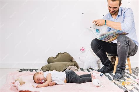 Padre Leyendo El Libro Al Bebé Que Duerme Foto Gratis