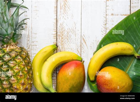 Variety Of Tropical Fruits Pineapple Mango Bananas On Large Palm Leaf