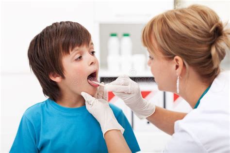 Doctor Checking The Throat Of A Young Boy Stock Image Image Of