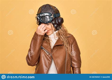 Young Beautiful Blonde Aviator Woman Wearing Vintage Pilot Helmet Whit Glasses And Jacket Tired