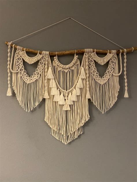 The Wall Hanging Is Made With Macrame And Tassels Which Are Hung On A