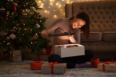 Free Photo Pretty Brunette Woman Opens An Adorable Present With Lights