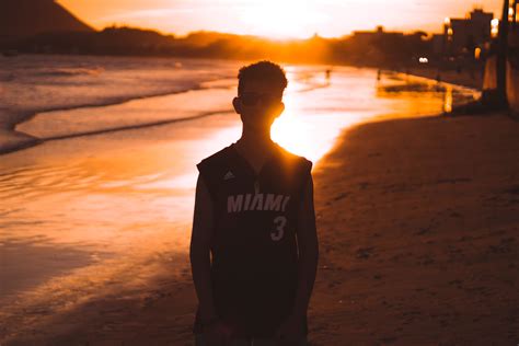 Man In Black Vest Standing On Beach During Sunset · Free Stock Photo