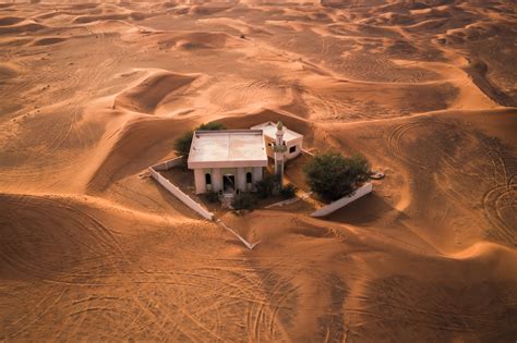 Maisons inhabitées enterrées sous le sable