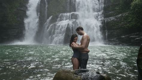 Wide Panning Slow Motion View Of Couple Swimming Near Waterfall Santa Juana Costa Rica Stock