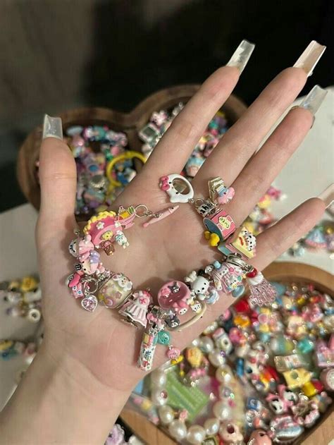 A Womans Hand With Many Bracelets And Rings On It Next To A Bowl Of Beads