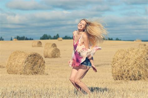 Premium Photo Beautiful Blonde Jumps In Sloping Field Sun Happiness