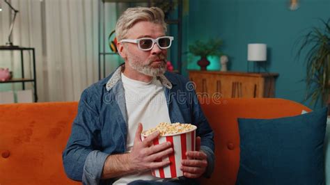 Man Sitting On Couch Eating Popcorn And Watching Interesting Tv Serial
