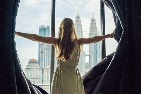 Young Woman Opens The Window Stock Photo Containing Woman And City
