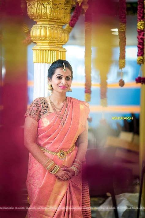 a woman in a pink sari posing for the camera