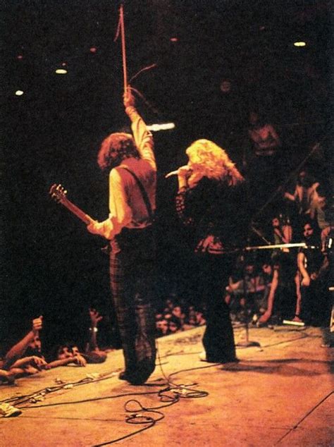 Two People Standing On Stage With Guitars And Microphones In Their