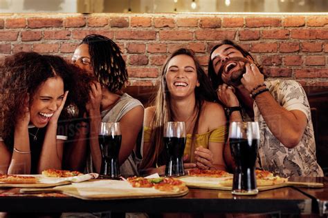 Group of happy multiracial friends having party at pizza restaurant 