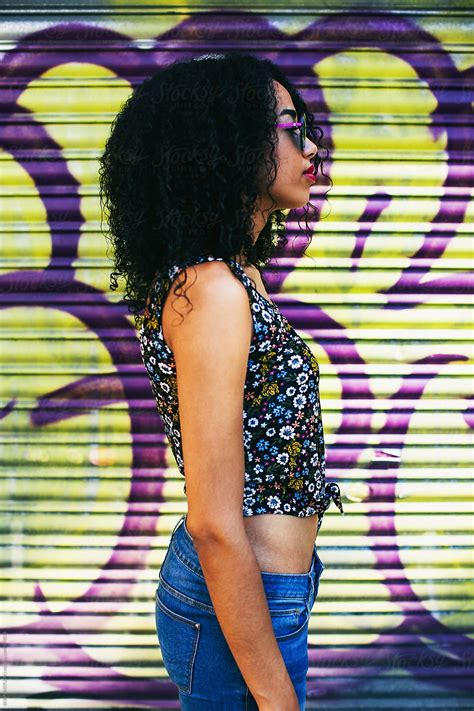 Side View Of A Young Latin Afro Woman Standing In Front Of A Shutter