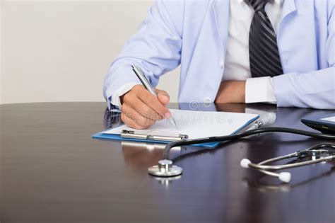 Doctor Writing Rx Prescription In Medical Office Clinic On Desk