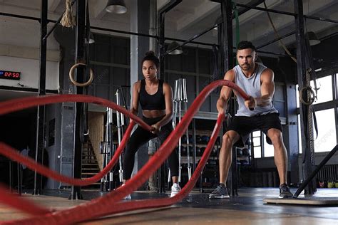 A Fit Couple Engages In Battle Rope Workout At A Functional Training