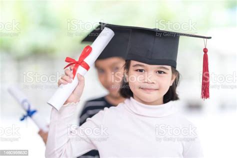 Graduation Concept With Two Happy Southeast Asian Schoolgirls With