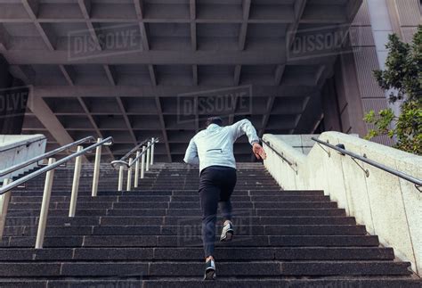 Man Running Up The Stairs Of A Building Athlete Climbing Stairs As Part Of His Physical