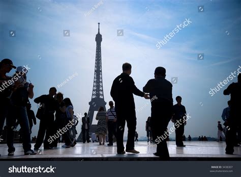 Group Of Tourists Walking And Taking Pictures Of Eiffel Tower Stock