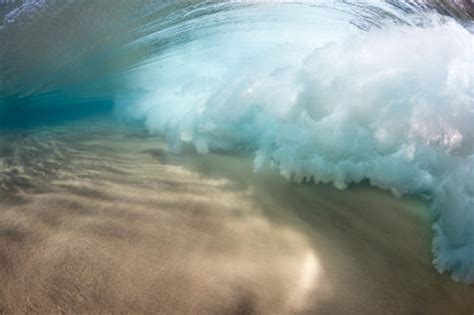 Underwater View Of A Breaking Wave As The Surf Crashes Over A Sandy