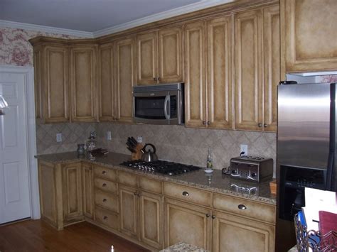 Give your dated kitchen cabinets a new look with a fresh coat of paint. Kitchen Cabinets Faux Painting