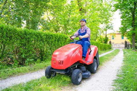 Professional Lawn Mower Worker Cutting Grass In Home Garden Stock Image
