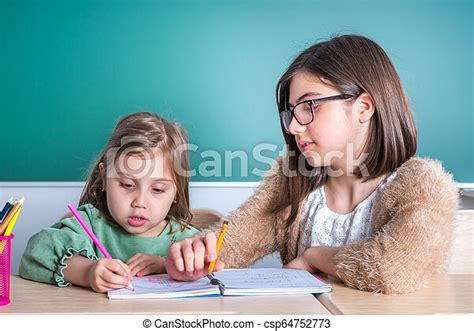 La Hermana Mayor Mira A Su Hermana Menor Mientras Dibuja En Un Cuaderno