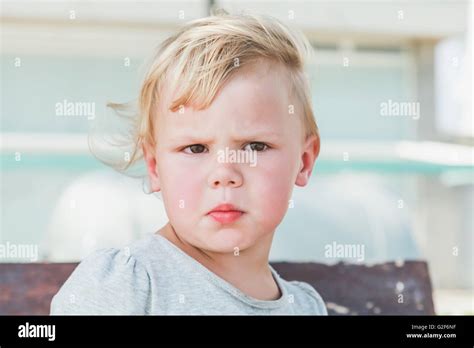 Outdoor Closeup Portrait Of Confused Cute Caucasian Blond Baby Girl