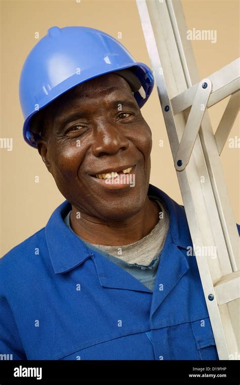 african american construction worker handyman carpenter carrying ladder over shoulder stock