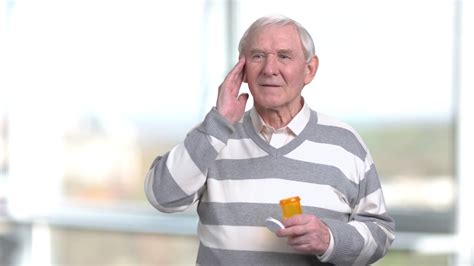 Senior Man Touching His Temple Headache Elderly Man With Bottle Of