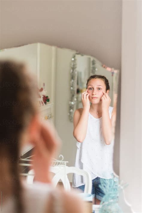 teen girl looking at her reflection in the mirror by stocksy contributor gillian vann stocksy