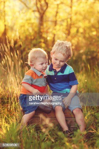 Two Blonde Brothers Sitting Together On A Crate High Res Stock Photo