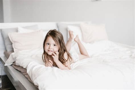 Charming Little Girl Lying On Bed By Stocksy Contributor Alina