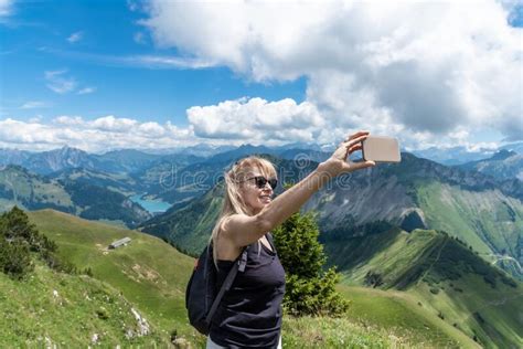 Blonde Mature Woman With Sunglasses Taking Selfie With Smartphone Swiss Alps And Lake Behind