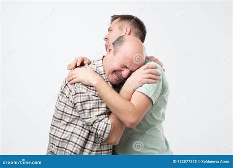 Elder Father Is Crying On His Son Shoulder And Feeling Upset Cause From