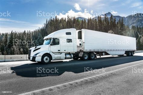 A White Semitruck Driving On Mountain Road Stock Photo Download Image