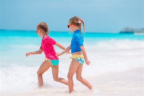 Dos niñas felices se divierten mucho en la playa tropical jugando juntos Foto Premium