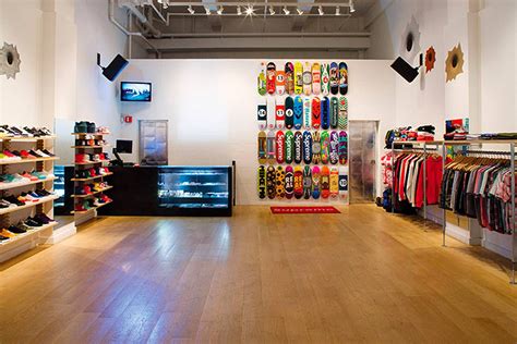 The Inside Of A Clothing Store With Wooden Floors And Shelves Filled