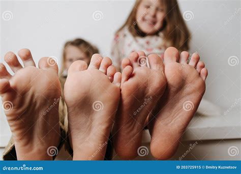 Children`s Feet Close Up To The Camera Their Blurred Faces In A
