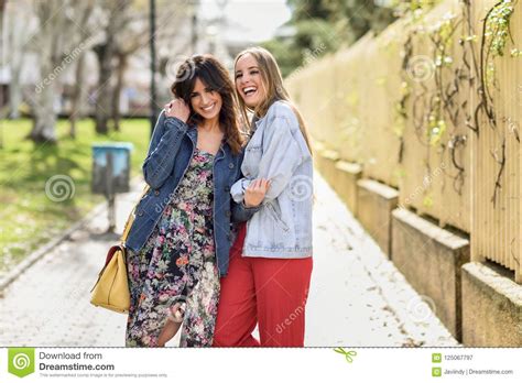 Two Happy Young Women Friends Hugging In The Street Stock