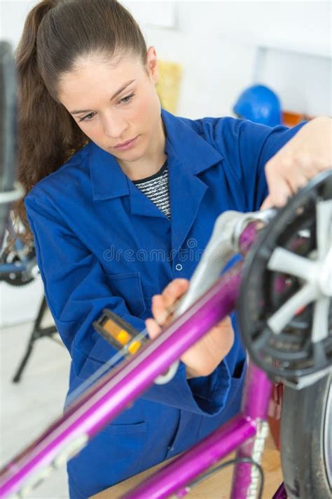 Bicycle Mechanic Repairing Wheel On Bike In Workshop Stock Photo