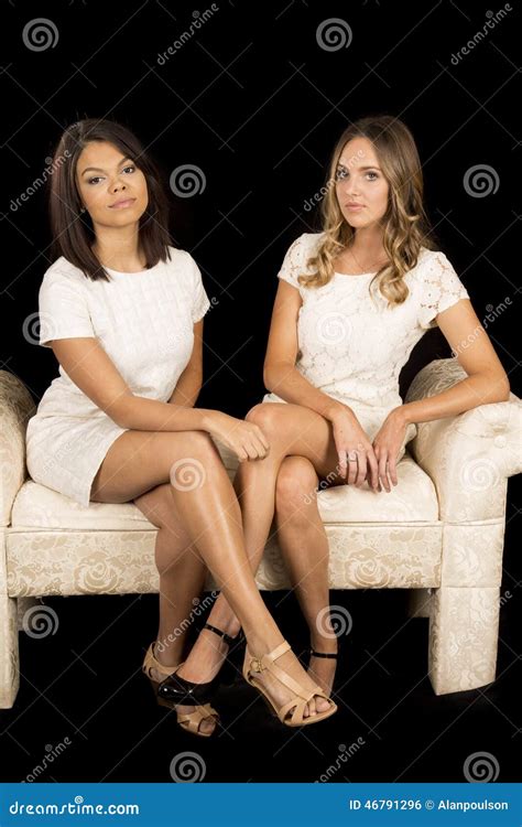 Two Women White Dress On Black Facing Legs Crossed Stock Photo Image